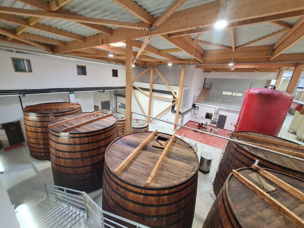 Vue intérieure des nouveaux ateliers de la Vinaigrerie Martin Pouret, avec des tonneaux de chêne destinés à la fabrication artisanale du vinaigre.