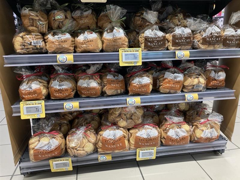 Un rayon de supermarché présentant plusieurs paquets de sablés de Nançay, accompagnés d'une signalétique "© du Centre" mettant en avant leur origine régionale.