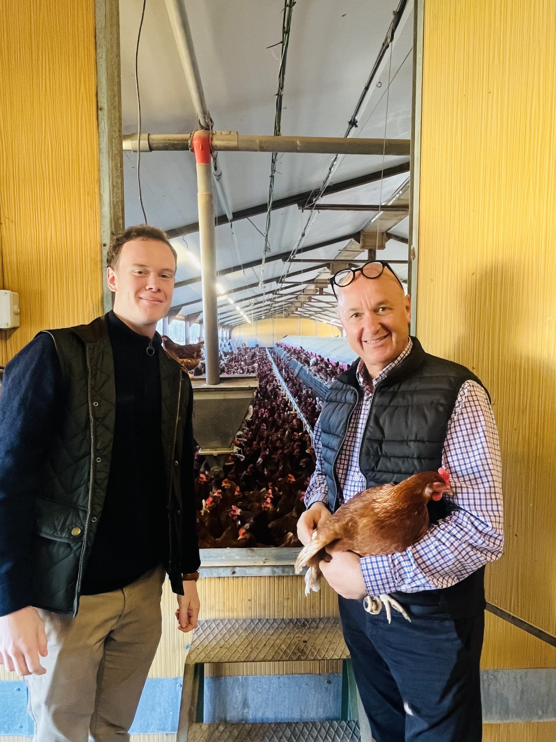 Emmanuel Choiseau (à droite avec une poule dans les bras) et son fils Jonathan devant la porte de leur poulailler.